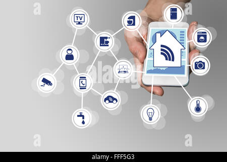 Hand holding modern smart phone on neutral background. Smart home automation concept with connected devices Stock Photo