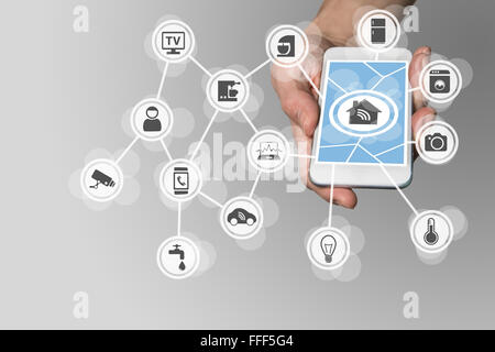Smart home concept with hand holding modern smart phone to control home appliances via the internet Stock Photo