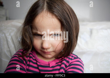 Angry three years old  little girl, sulking and pouting. Indoors portrait Stock Photo