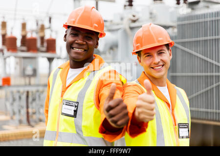handsome electricians giving thumb up in substation Stock Photo