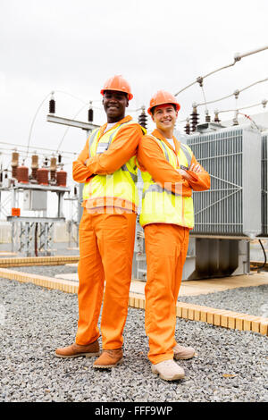 multiracial electrical co-workers in electric substation Stock Photo
