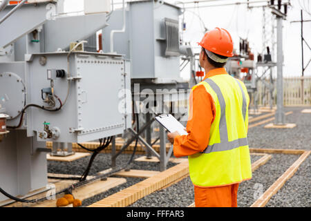 back view of electricity company substation worker Stock Photo