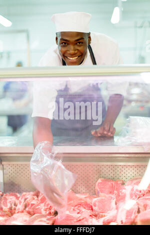 happy young African butcher helping customer Stock Photo