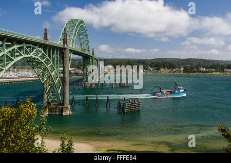 Yaquina Bay Bridge with fishing boat heading out to sea,  Newport, Oregon Stock Photo