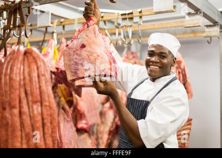 happy African American butcher handing red meat in butchery Stock Photo