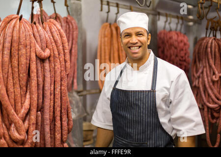 portrait of happy male butcher standing in butchery Stock Photo