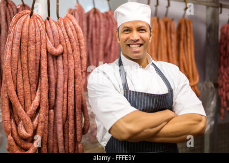portrait of mid age butcher with arms crossed in butchery Stock Photo