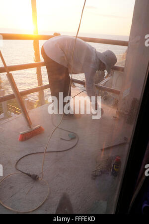 Workman using a grinder on drill without a facemask to cut cement terrace in Mexico. Stock Photo