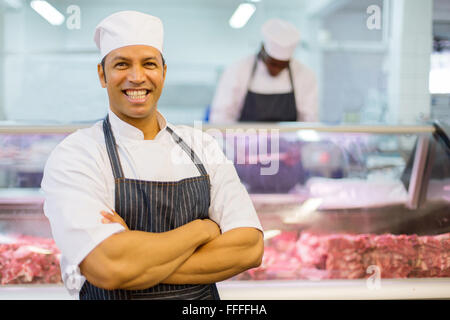 portrait of handsome mid age male butcher with arms folded Stock Photo