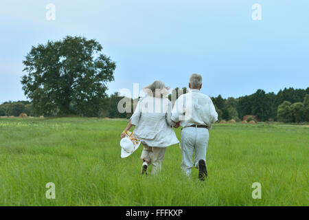 Senior couple running at   field Stock Photo