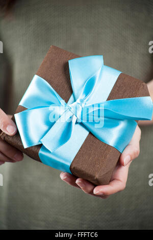 gift box in woman hands over library background Stock Photo