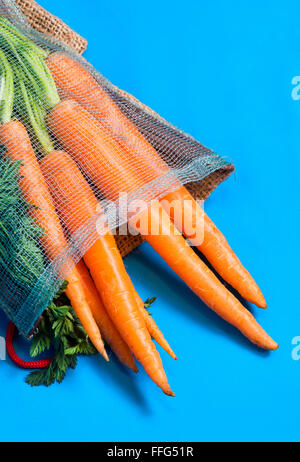 carrots with leaves on blue background Stock Photo