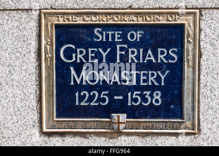 A commemorative blue plaque on the site of the Grey Friars Monastery (1225 -1538) on display on a wall in London,United Kingdom. Stock Photo