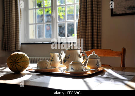 Stillife of coffee ceramics and melon on a table with sunbeams France Europe Stock Photo
