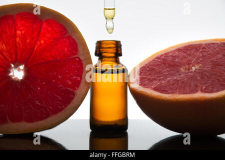 Essential oil amber glass bottle with grapefruit slices, with dropper Stock Photo