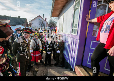 Koliadnyky - group of adult and kids dressed in costumes of soldiers and traditional Ukrainian female costumes - sing carols (koliadky) during Malanka celebration in Velykyj Kuchuriv village, Bukovina, Ukraine Stock Photo