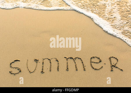 Summer - word drawn on the sand beach with the soft wave. Stock Photo