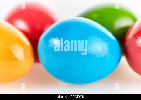 Five colorful easter eggs in different colors lying on white background Stock Photo