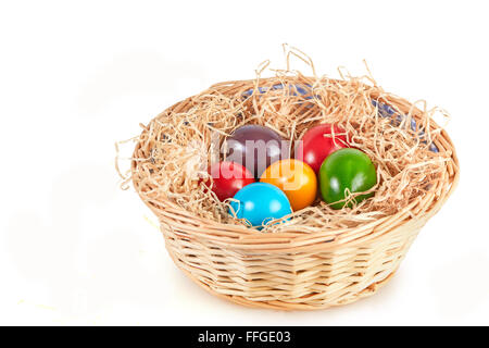 Isolated easter basket with six colored easter egss and hay Stock Photo