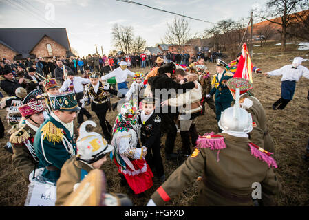 Koliadnyky - group of adult and kids dressed in costumes of soldiers and traditional Ukrainian female costumes - dance in a ring at the yard of the host house during Malanka celebration in Velykyj Kuchuriv village, Bukovina, Ukraine Stock Photo