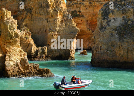 Tourists enjoying the view of the spectacular rock formations from a boat Stock Photo