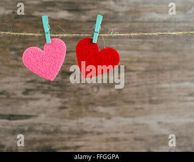 two red and  pink hearts hanging on a cord Stock Photo