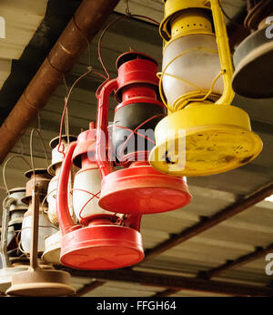 Colorful vintage kerosene gas lanterns hanging from roof Stock Photo