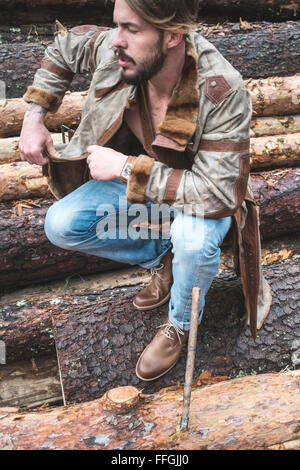 Young men on logs in the forest. Leather and jeans Stock Photo - Alamy