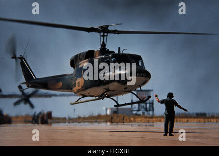 A ground crew member helps guide a UH-1N into position as the helicopter prepares to land at Hill Air Force Base, Utah, in 1975. Stock Photo
