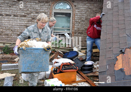 Master Sgt. Cherry Bina, 137th Maintenance Group, Oklahoma Air National Guard, recovers personal items from her house that was severely damaged after a devastating tornado hit in Moore, Okla. May 20, 2013. Stock Photo