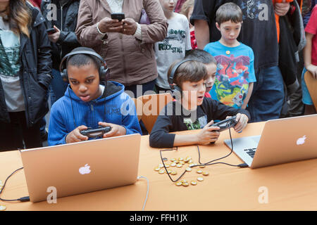 Children playing video games on Apple Powerbook laptop computers - USA Stock Photo