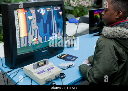 Young African-American boy playing Donkey Kong Country on Super Nintendo Entertainment System - USA Stock Photo