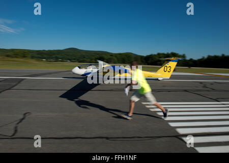 Wing-runners run along side and hold the wingtip of the glider level until it has enough speed for the pilot to take control during the Northeast Region Glider Academy in Springfield, Vt. In addition to holding the wingtip, the wing-runner communicates with both the glider and tow-plane pilots using hand signals. Stock Photo