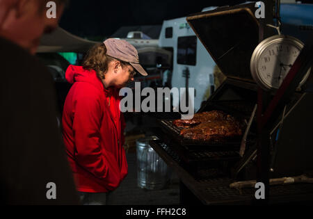 Margaret Houghton, Tech. Sgt. Todd Houghton's wife, checks the internal temperature of their beef brisket shortly after 3:30 a.m., while at their regional qualifying competition in Atlanta, Ga. Houghton and members of his team, Hoot 'N' Annie Q, slow cooked different meats throughout the night, ultimately earning them a finalist spot in the inaugural Air Force High Flyin' BBQ Challenge in San Antonio. Stock Photo