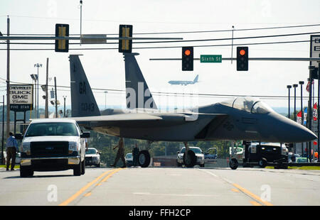 Airmen maneuver through traffic lights while towing an F-15 Eagle to the Warner Robins City Hall in Warner Robins, Ga. The aircraft was loaned to the city by the Georgia Air National GuardÕs 116th Air Control Wing to serve as a static display for a new veteranÕs memorial. The Airmen moving the aircraft are assigned to the 116th Maintenance Group. Stock Photo