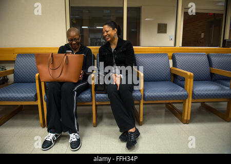 Staff Sgt. Chantel Thibeaux, Joint Base-Fort Sam Houston, Texas, dental assistant instructor, shares a laugh with her mother Carla while watching a video on her phone. As Thibeaux and her mother waited for doctors to perform checks prior to double mastectomy surgery, Carla kept her daughter in good spirits with laughs and loving reminders. Stock Photo