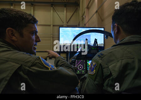 A U.S. Air Force instructor pilot assigned to the 81st Fighter Squadron, Moody Air Force Base, Georgia, reviews the flight after an Afghan student pilot landed in the A-29 Super Tucano flight simulator. Students work with their U.S. instructors to build familiarity and proficiency in the simulator before flying the A-29. The A-29 is a two-seat aircraft, allowing students to fly with U.S. instructor pilots in the back seat. The American instructor pilot can take control of the aircraft at any time, but the students are expected to fly the aircraft through the entire mission. Stock Photo