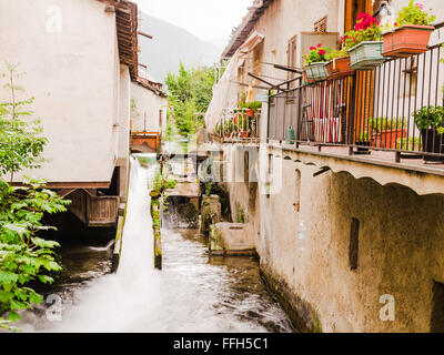 sights of a beautiful corner of an italian small village over the alps. example of rural architecture with a metal dam that chan Stock Photo