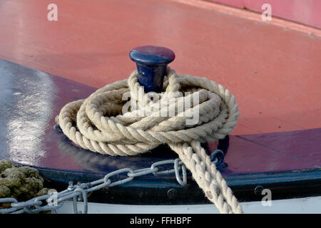 Rope tied to mooring post on canal boat to stop it floating away Stock Photo