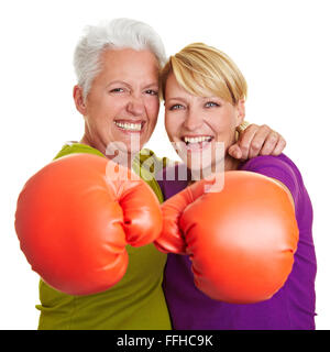 Two happy senior women boxing with red boxing gloves Stock Photo