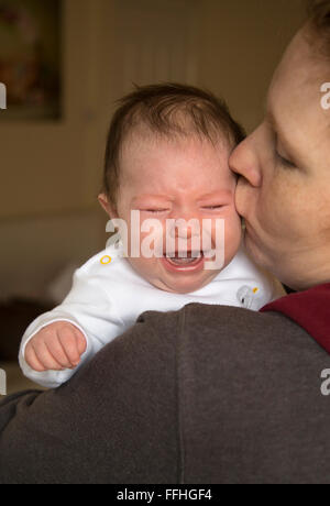 baby girl crying on mums shoulder Stock Photo