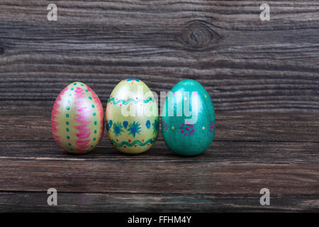Three Easter eggs on wooden background Stock Photo