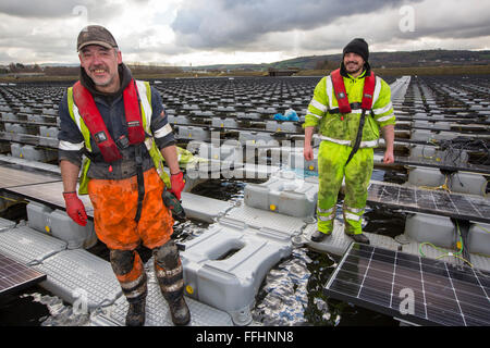 The new floating solar farm being grid connected on Godley Reservoir in Hyde, Manchester, UK. The scheme is a 3 MW system, comprising of 10,000 photo voltaic panels. It will cut United Utilities electricity bill at the water treatment plant on site, by around £7,000 a month. It is the largest floating solar farm in Europe and the second largest in the world. It will provide around 33% of the water treatment plants energy needs. Stock Photo