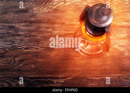 Old rusty kerosene lantern on wooden structured floor Stock Photo