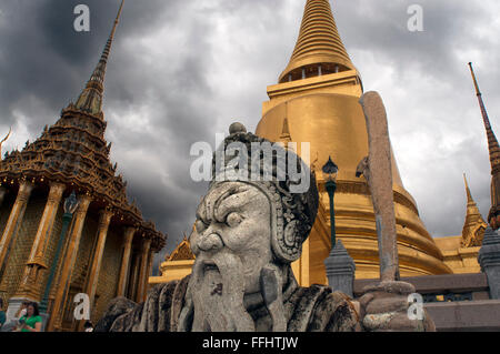 Golden Stupa and stone Guardian Wat Phra Kaew near the Royal Grand Palace Bangkok Thailand. Guardian giant in front of Phra Sri