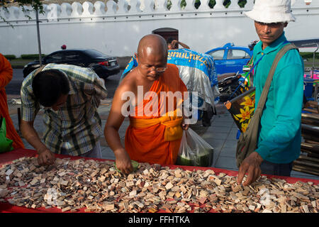 Buddhist monk and another people buying a amulets, periapts. Amulet market. Bangkok. Buddhist monks seen looking at protective a Stock Photo