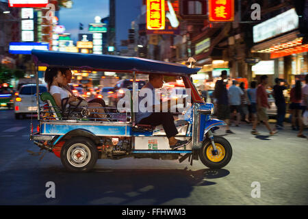 Tuk tuk in the street. View down Thanon Yaowarat road at night in central Chinatown district of Bangkok Thailand. Yaowarat and P Stock Photo