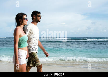 Happy young couple taking a walk holding hands on the beach. Stock image Stock Photo