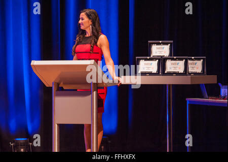 MAASTRICHT, THE NETHERLANDS - OCTOBER 25, 2015: Master of ceremonies behind pulpit addresses theatre crowd with microphone Stock Photo
