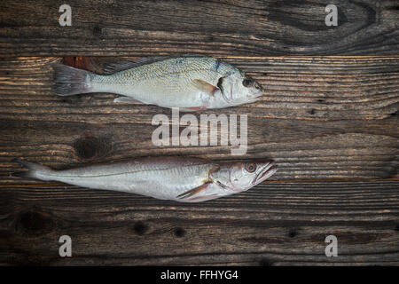 Raw fishes over wooden background, top view Stock Photo